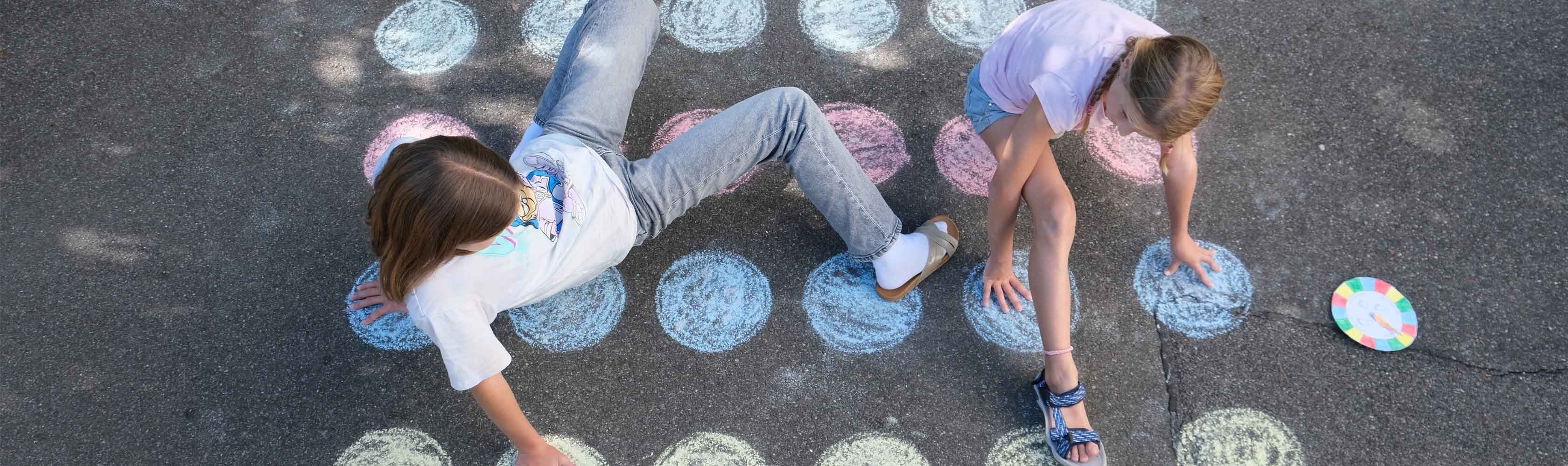 Twister– zwei Kinder spielen Twister draussen