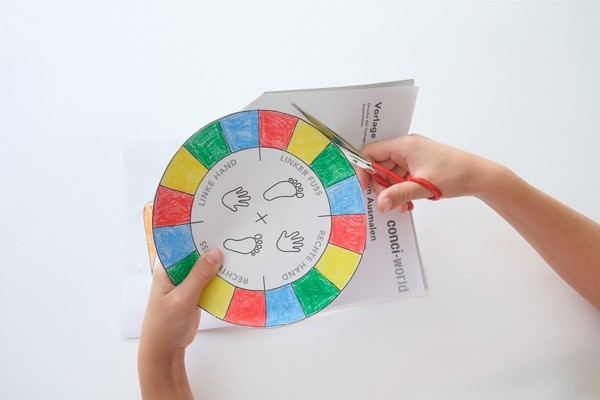 Twister– Kind schneidet Vorlage aus