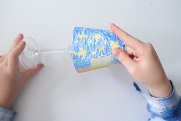 Windlicht – Kind klebt Vorlage auf Weinglas