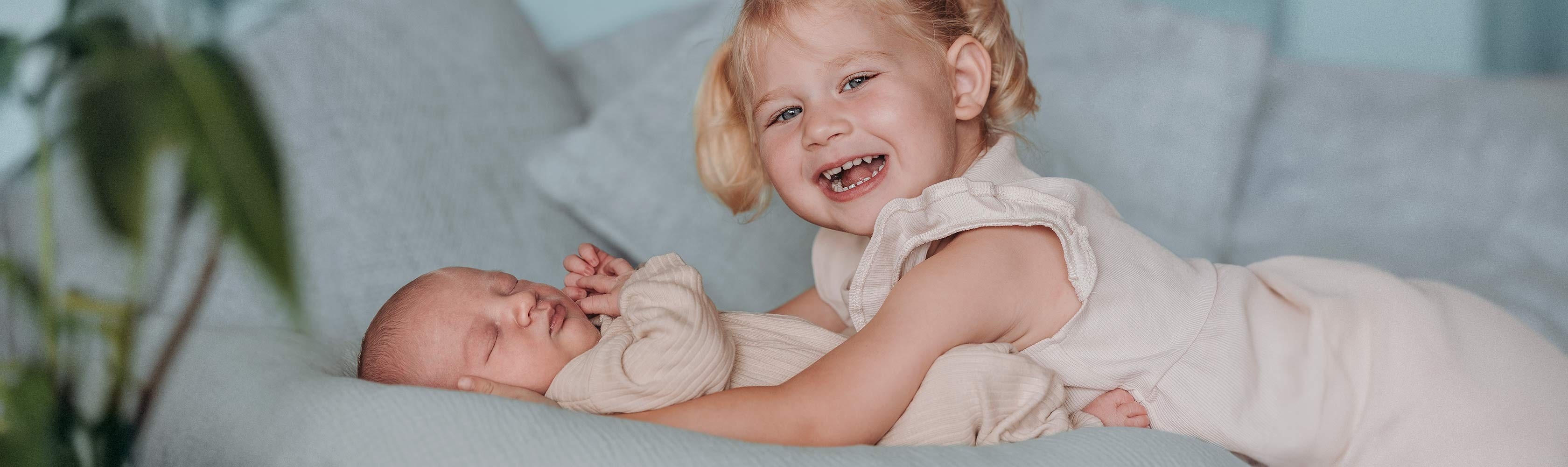 Kind ist da – Schwester schaut ganz behutsam zu ihrem neugeborenen Geschwisterchen