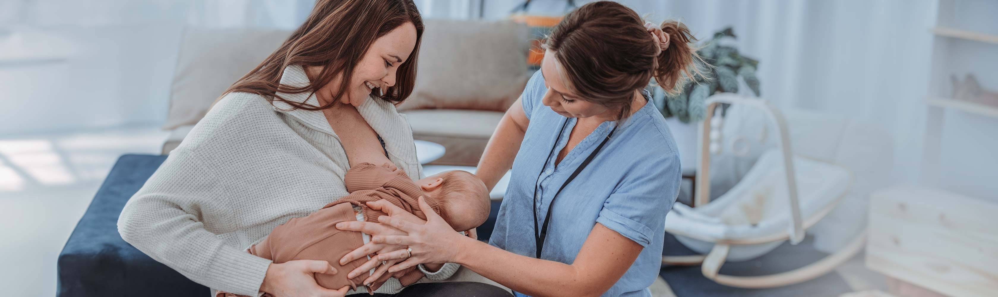 Stillberatung – Mutter stillt ihr Baby und die Hebamme zeigt ihr wie es am besten geht