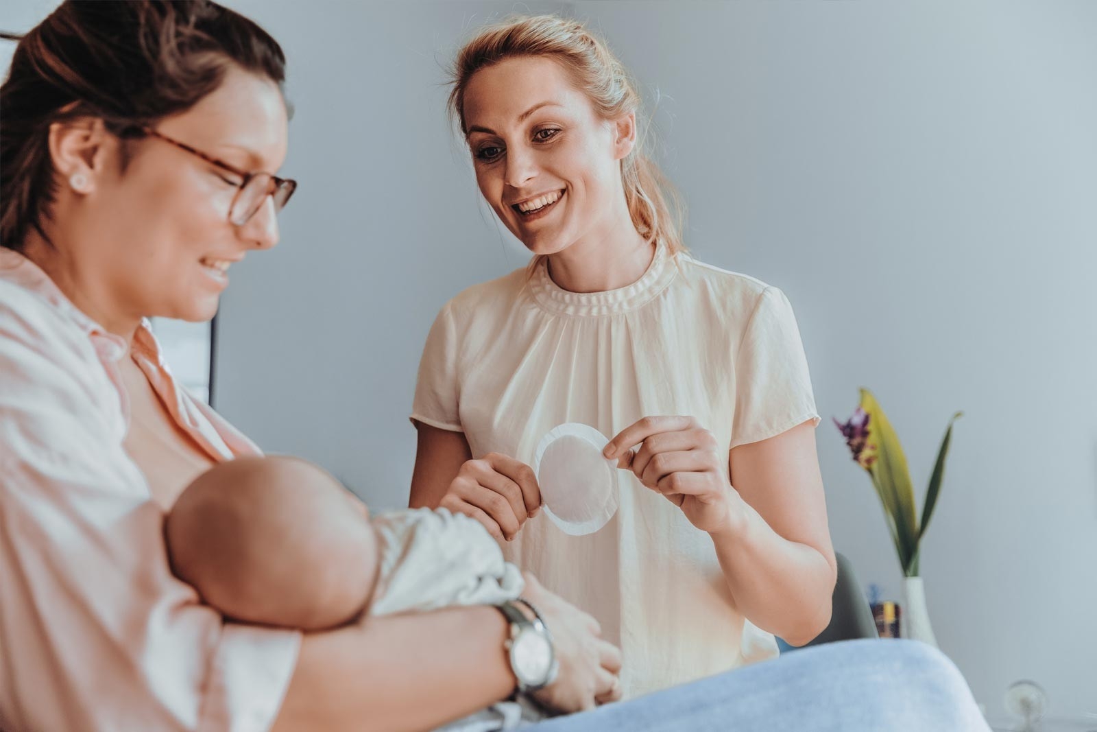 Stillberatung – Mutter stillt ihr Baby und die Hebamme berät sie 