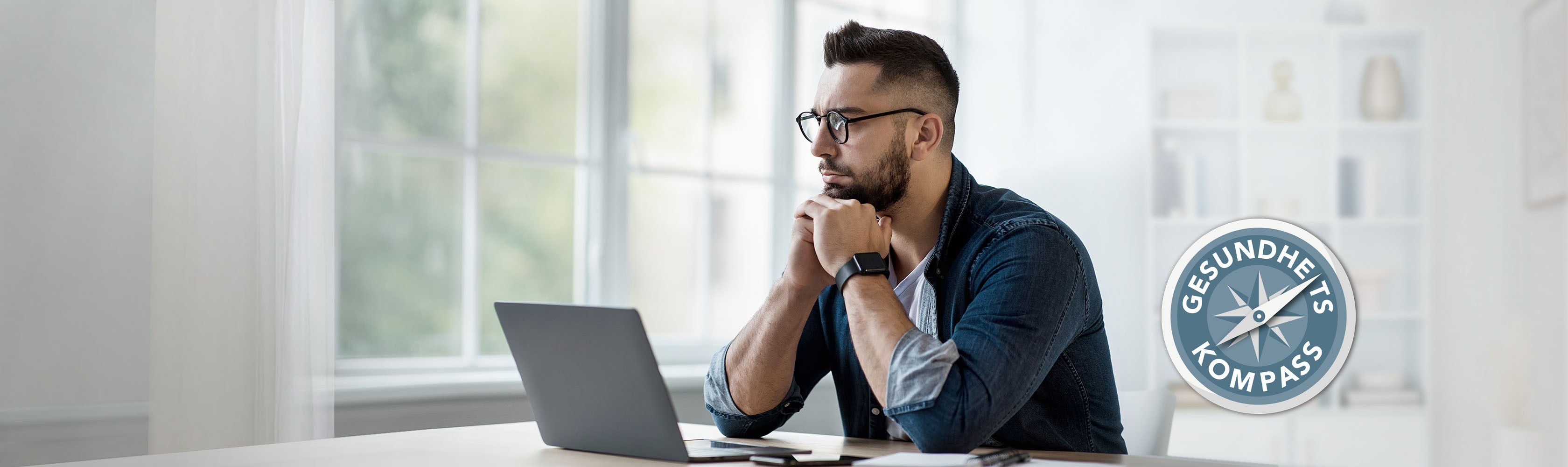 Mental Health – Mann sitzt vor dem Laptop und macht sich Gedanken, das Gesundheitskompass Logo ist daneben