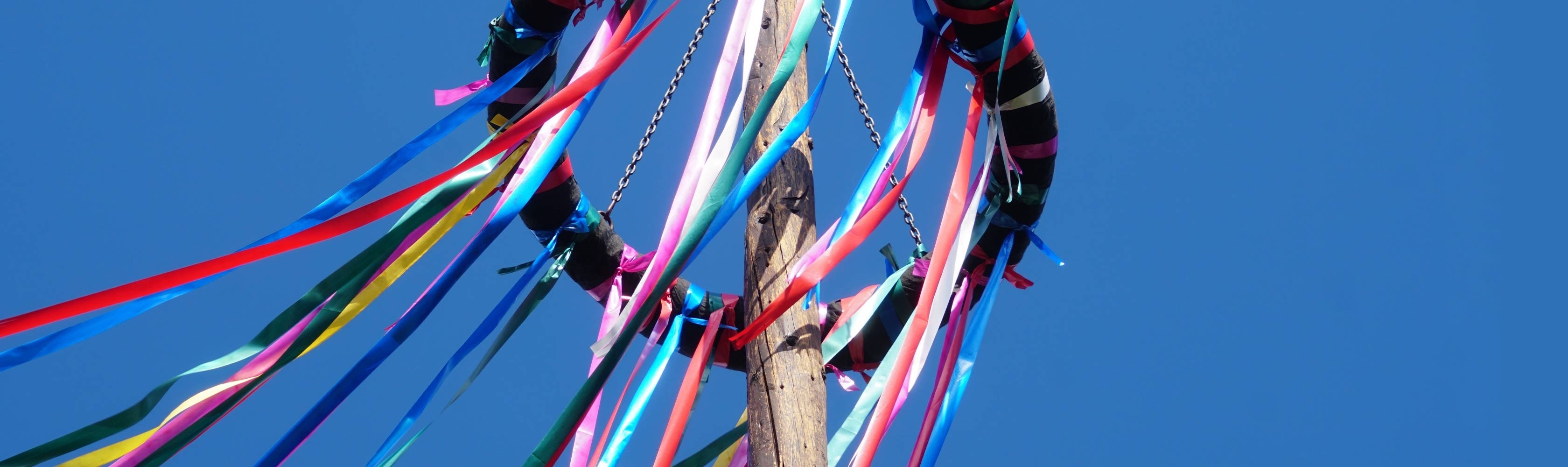 Conci-Blog Februar-23 - Ein Maibaum ist mit vielen, farbigen Bändern geschmückt.