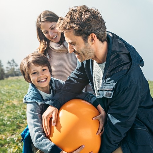 Eltern und Sohn spielen mit einem Ball