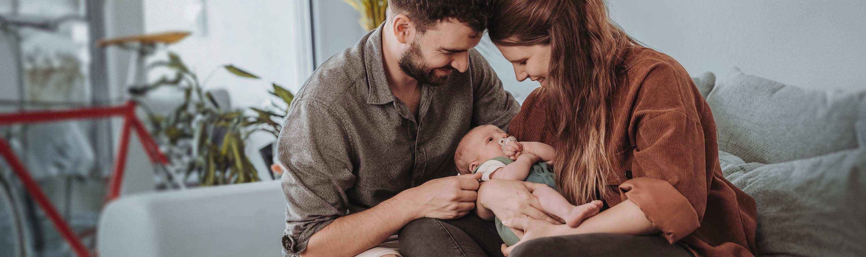 Family insurance – young parents holding their baby with love