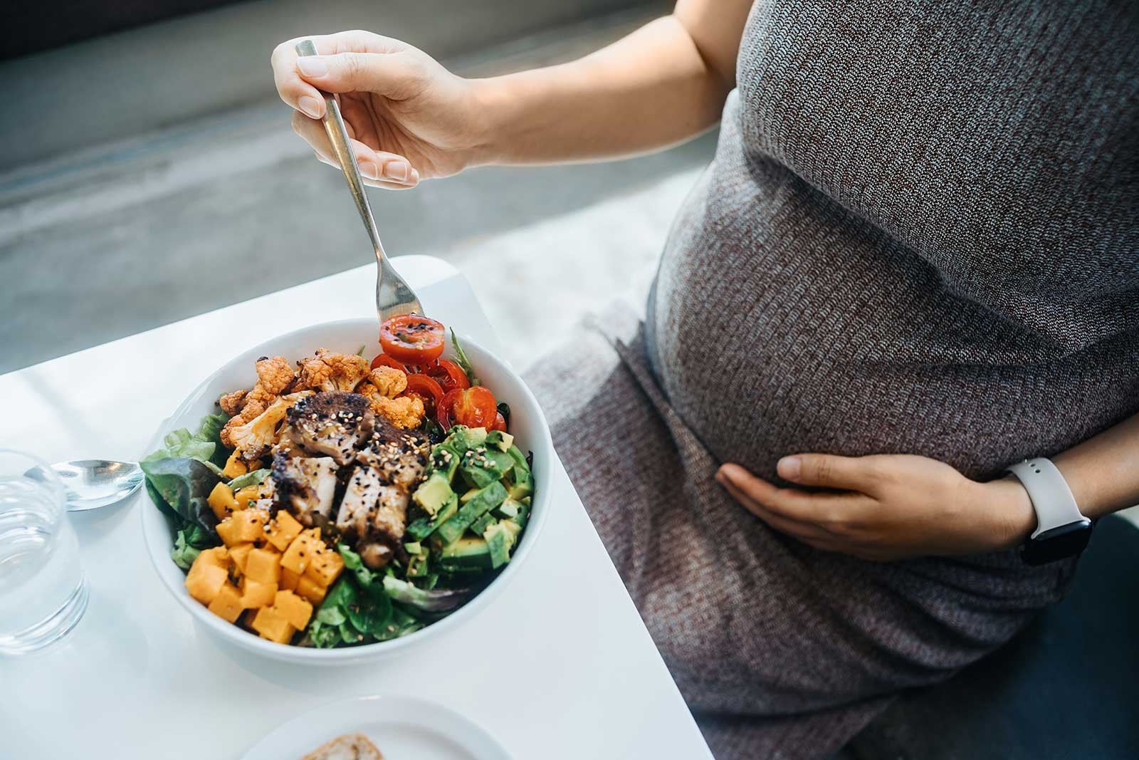 Pregnancy and diet – a pregnant woman eats a healthy salad bowl 
