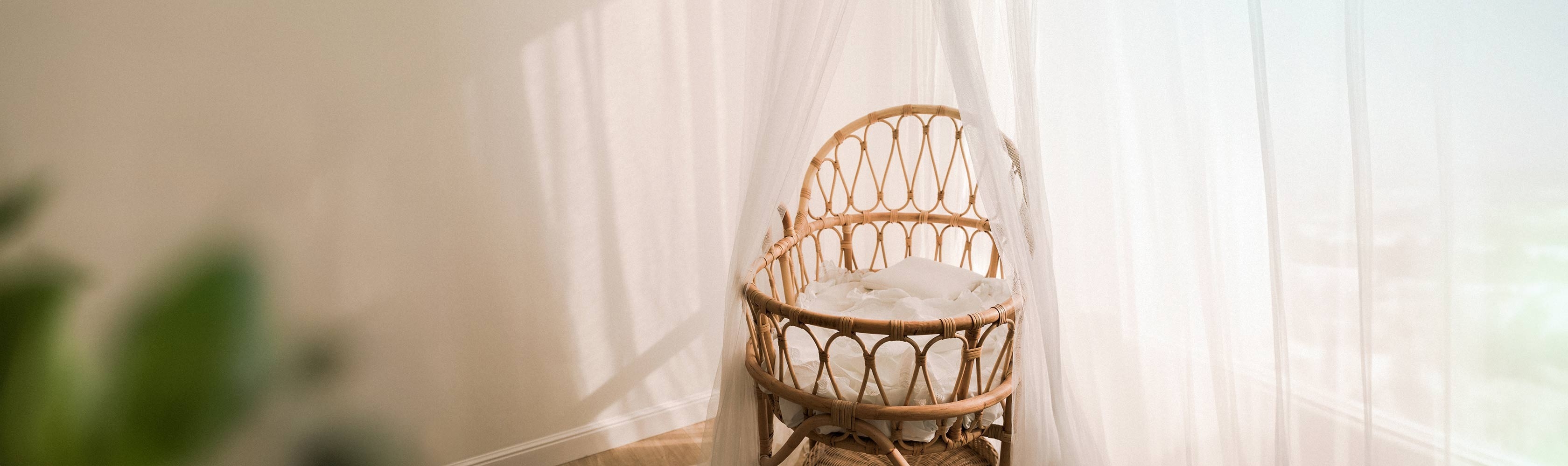 Miscarriage – an empty wooden cot under a light curtain
