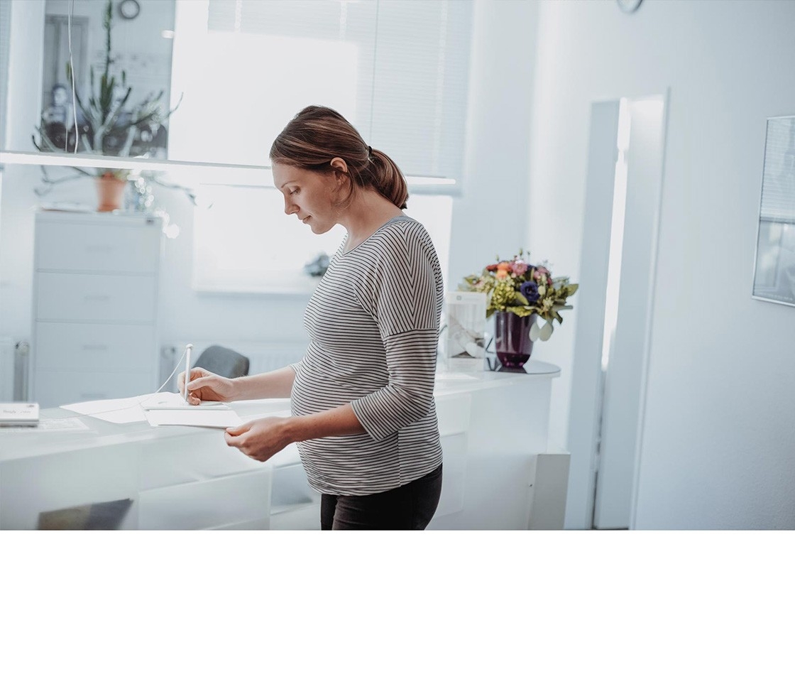 Pre-term birth – a pregnant woman fills out a form in the clinic