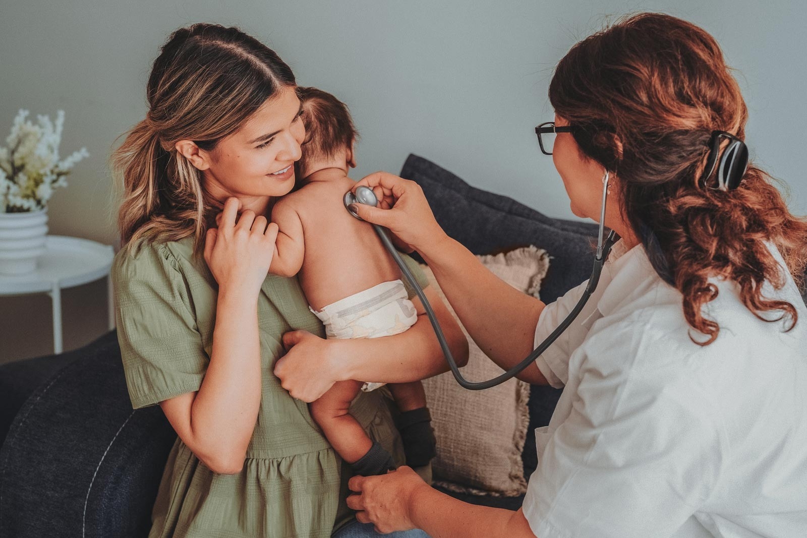 Midwives – a midwife auscultates a newborn baby with a stethoscope