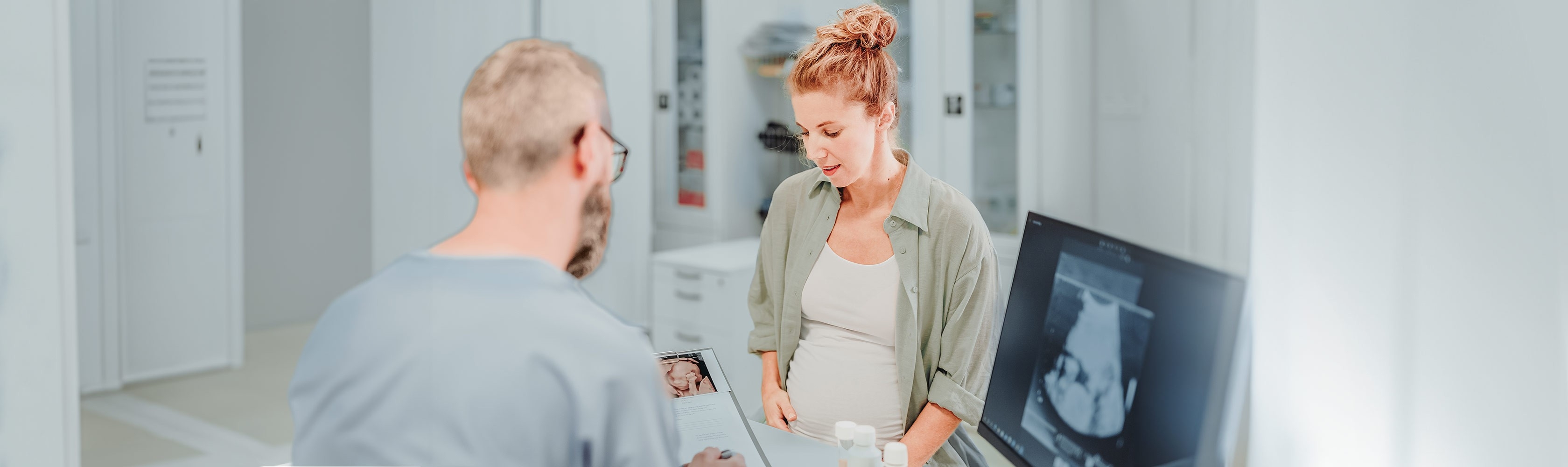 Prenatal tests– a pregnant woman discusses test results with her doctor