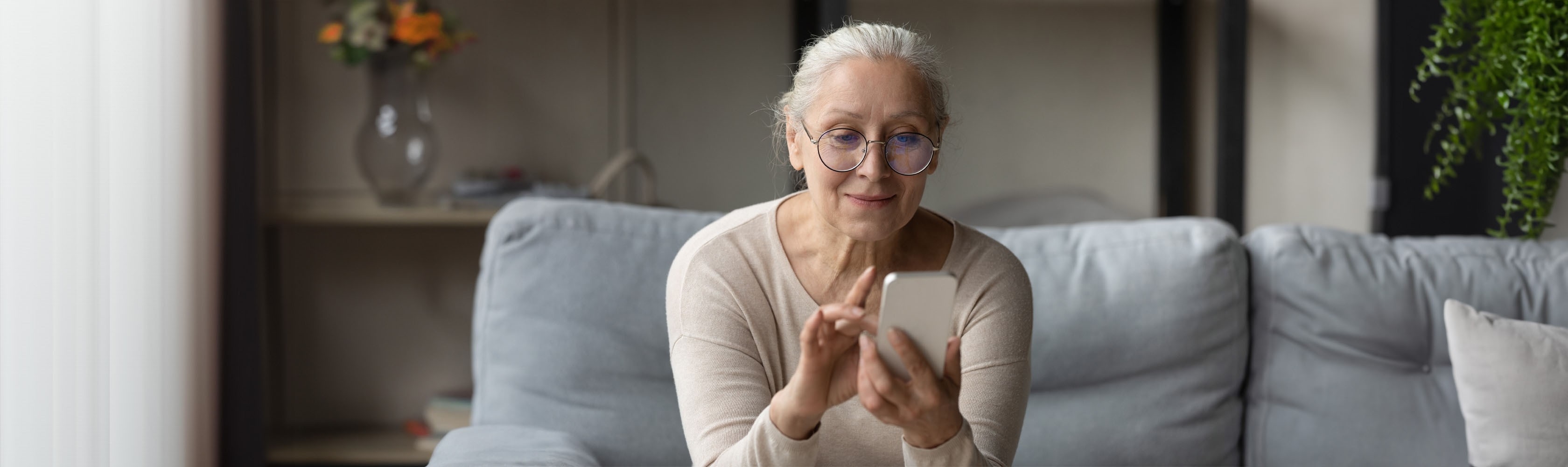 An elderly woman is using a prevention app on her smartphone.