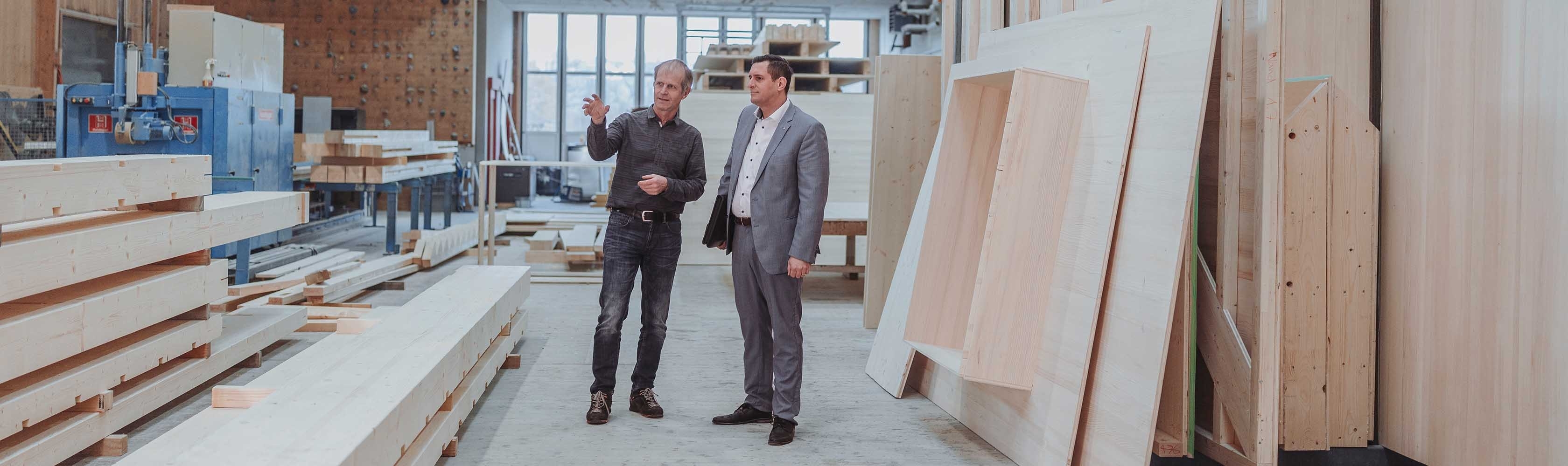 Contact - A man is sitting in an armchair with his briefcase at his feet, another man in a suit is standing to the left, leaning against something.
