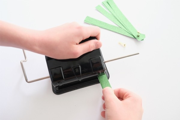 Christbaumkugeln – Kind locht Papierstreifen