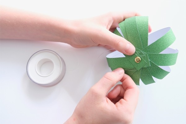 Christbaumkugeln  – Kind befestigt Faden an fertiger Christbaumkugel