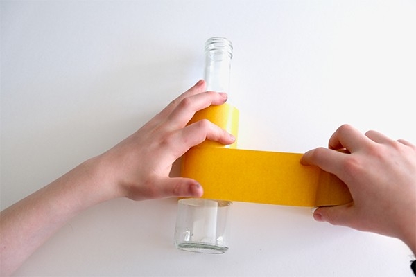 Vase à cordon - l'enfant met de la colle autour de la bouteille