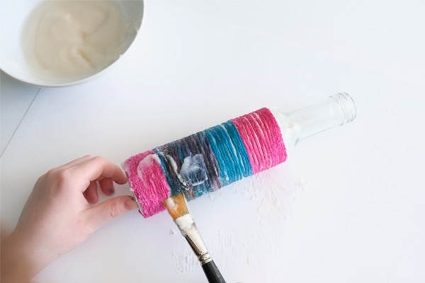 Vase en ficelle - L'enfant enduit le fil de colle liquide