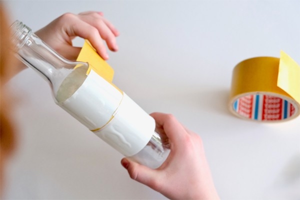 Vase en ficelle - l'enfant retire le film protecteur du ruban adhésif