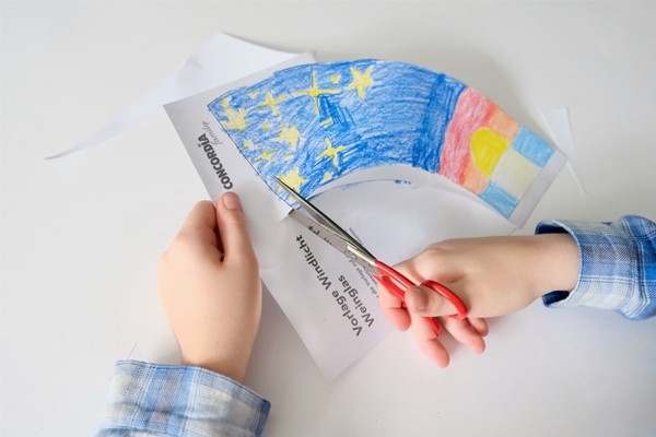 Windlicht – Kind schneidet ausgemalte Vorlage aus
