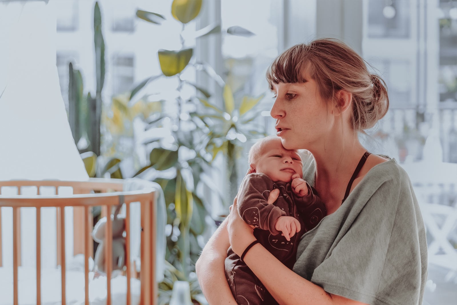 Baby blues - une femme est assise dans son salon et serre son bébé dans ses bras.