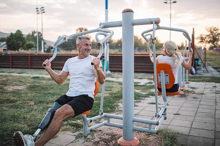 Un couple âgé fait de la musculation dans une salle de sport en plein air.