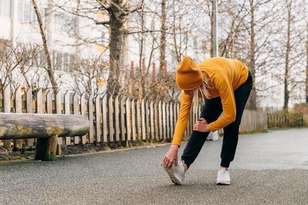 Une femme réalise son programme sportif quotidien et monte des escaliers en courant.