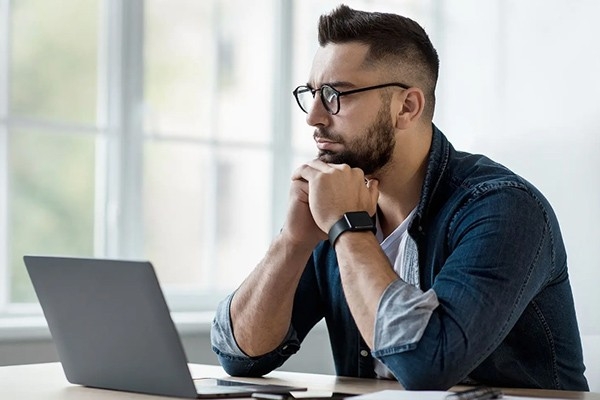 Un homme est assis devant son ordinateur portable et fait le test de santé mentale.