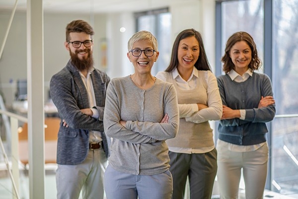 Des collaborateurs motivés regardent l'appareil photo avec joie et confiance.