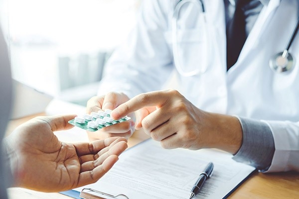 un médecin montre à un patient une variante moins coûteuse de ses médicaments