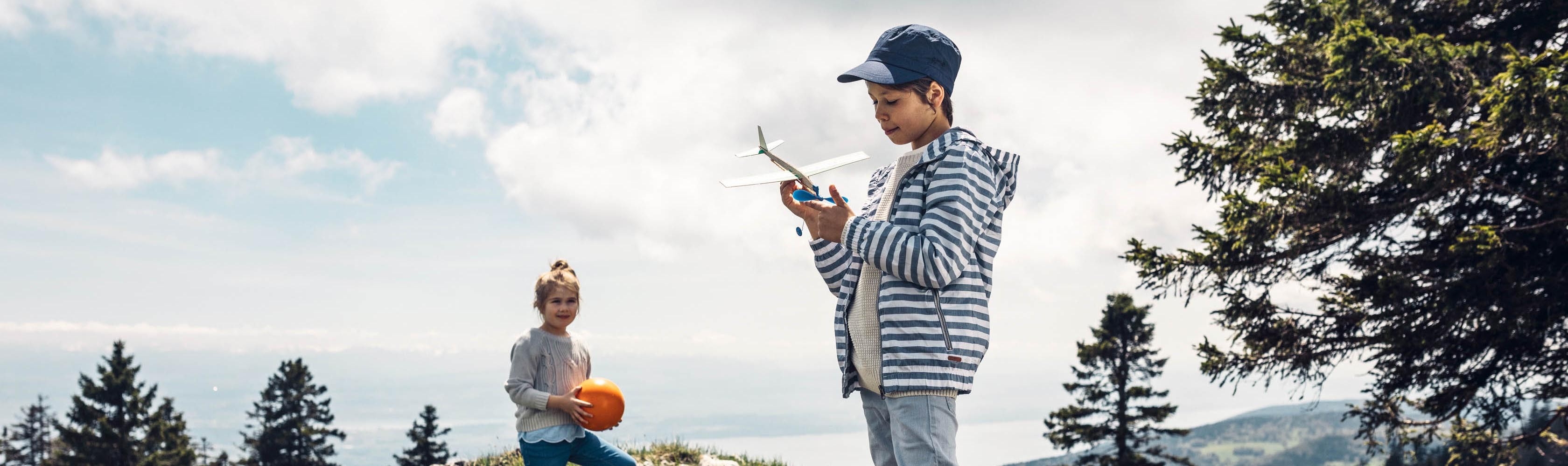 Cartes vacances et activités de loisirs - Un garçon joue avec un modèle réduit d'avion, en arrière-plan se trouve une fille avec un ballon CONCORDIA