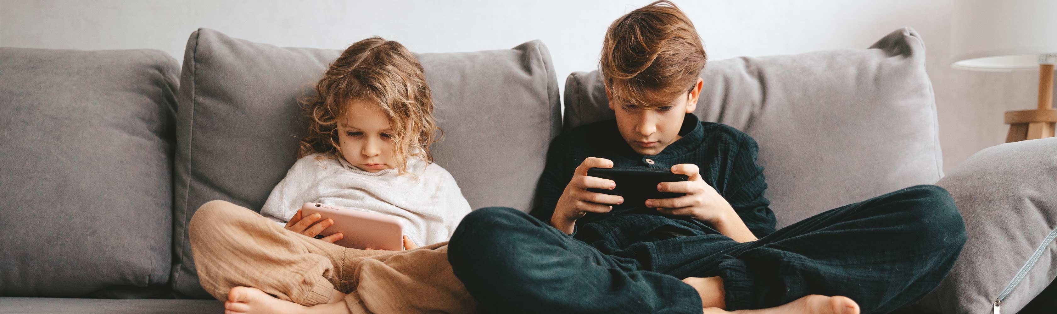 Safer Internet Day – zwei Kinder auf dem Sofa am Handy