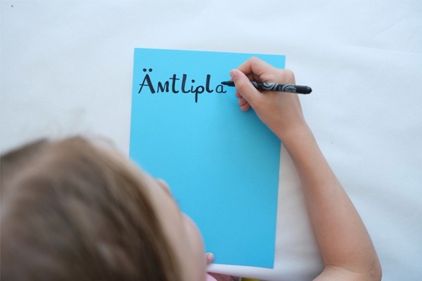 Ämtliplan: Kind schreibt auf ein farbiges Papier