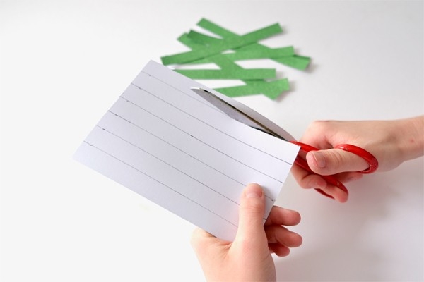 Christbaumkugeln – Kind schneidet Papierstreifen aus