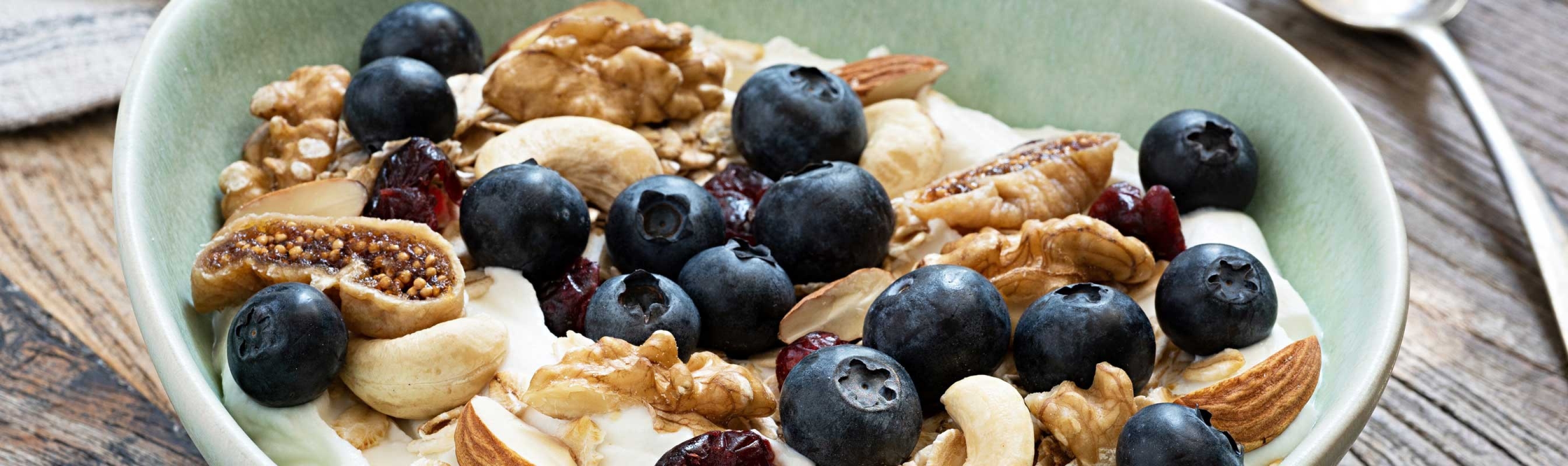 Una ciotola con noci, mirtilli, fiocchi d'avena e yogurt. 