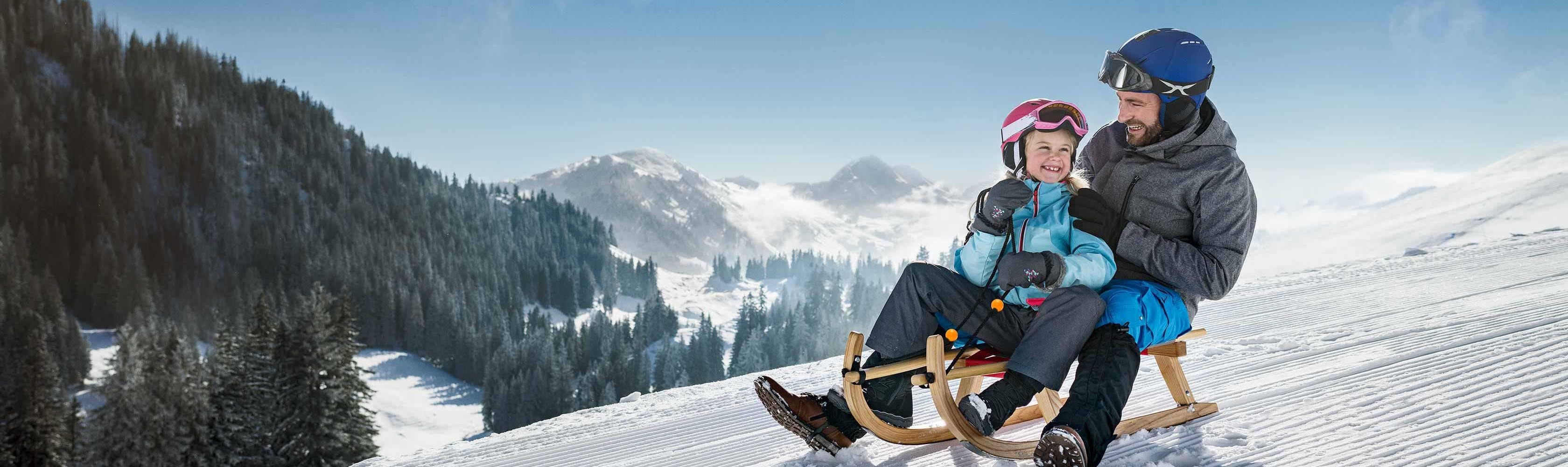 Un padre con la figlia su uno slittino