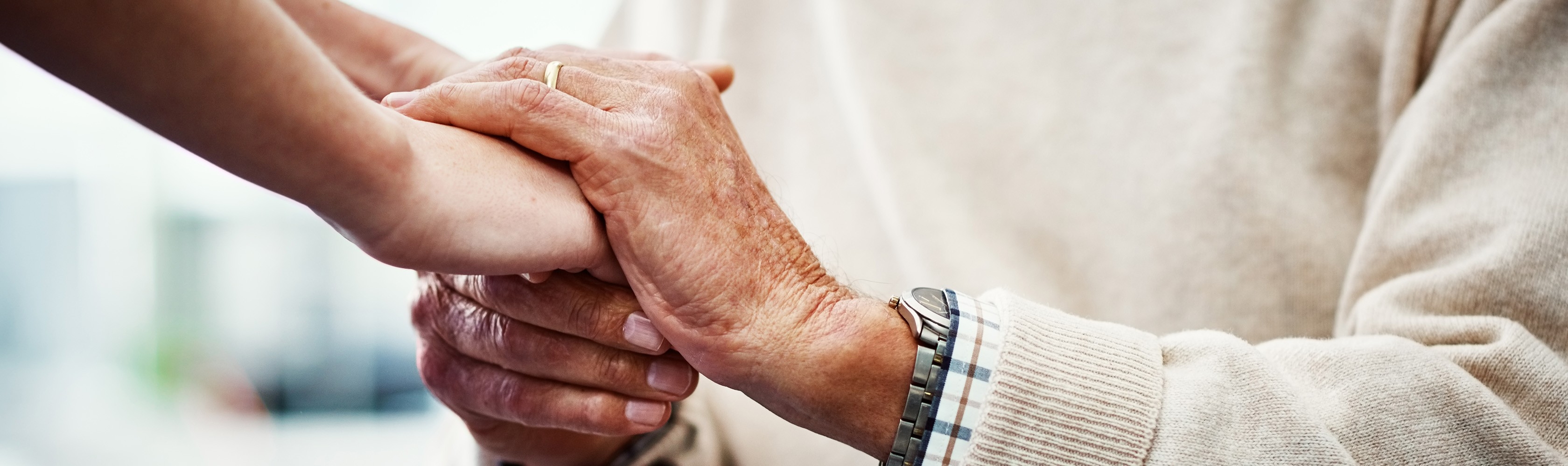 Mani giovani tengono mani anziane.