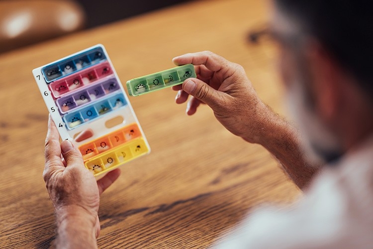 Un uomo organizza l'assunzione dei suoi farmaci