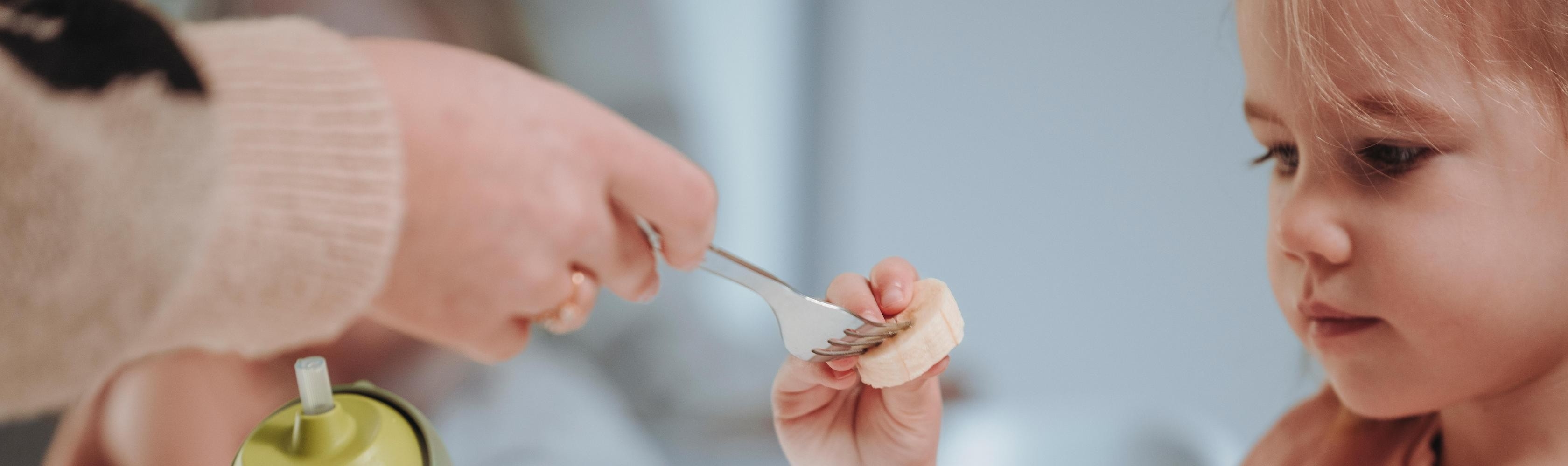 Una bambina assaggia con curiosità un piatto nuovo