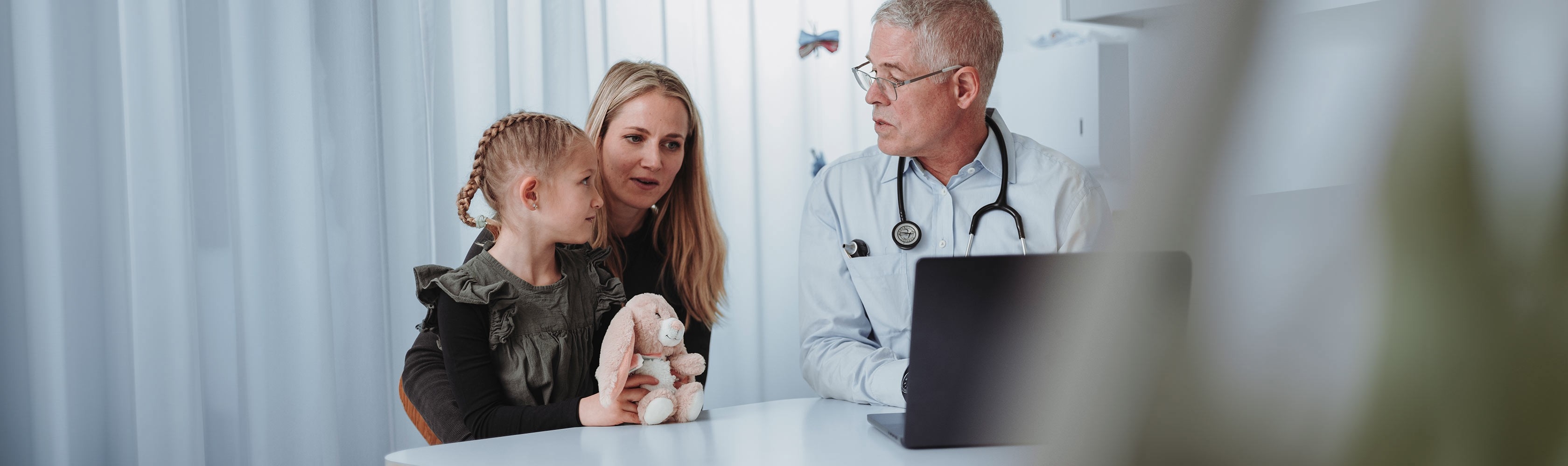 Informazioni annuali 2026 – Colloquio medico con madre e bambino in uno studio medico.