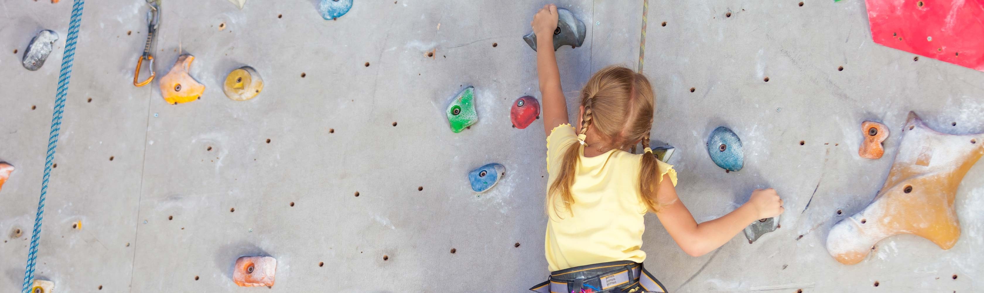 Mädchen klettert Indoor an einer Kletterwand