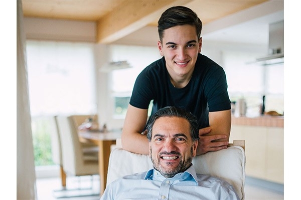 Crescenzo Savignano, Bereichsleiter im Departement Leistungsprüfung bei der CONCORDIA, übernimmt privat Verantwortung für seine Familie. Auf dem Bild sitzt er auf einem Stuhl, hinter ihm steht sein 16-jähriger Sohn.
