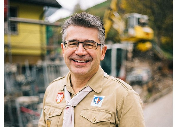 Heinz Polenz, Sicherheitsbeauftragte und Verantwortlicher Bauwesen, zeigt sich mit einem strahlenden Lächeln in seinem Pfadihemd. Privat trägt er die Verantwortung für den Um- und Anbau der Pfadihütte.