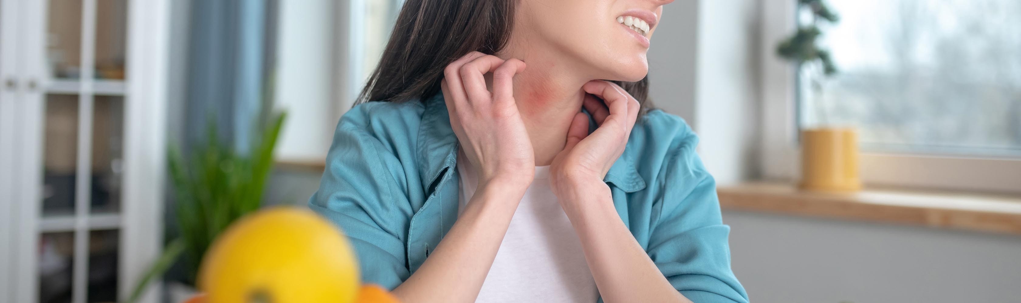 Kreuzallergien - eine Frau hat Juckreiz und kratzt sich am Hals