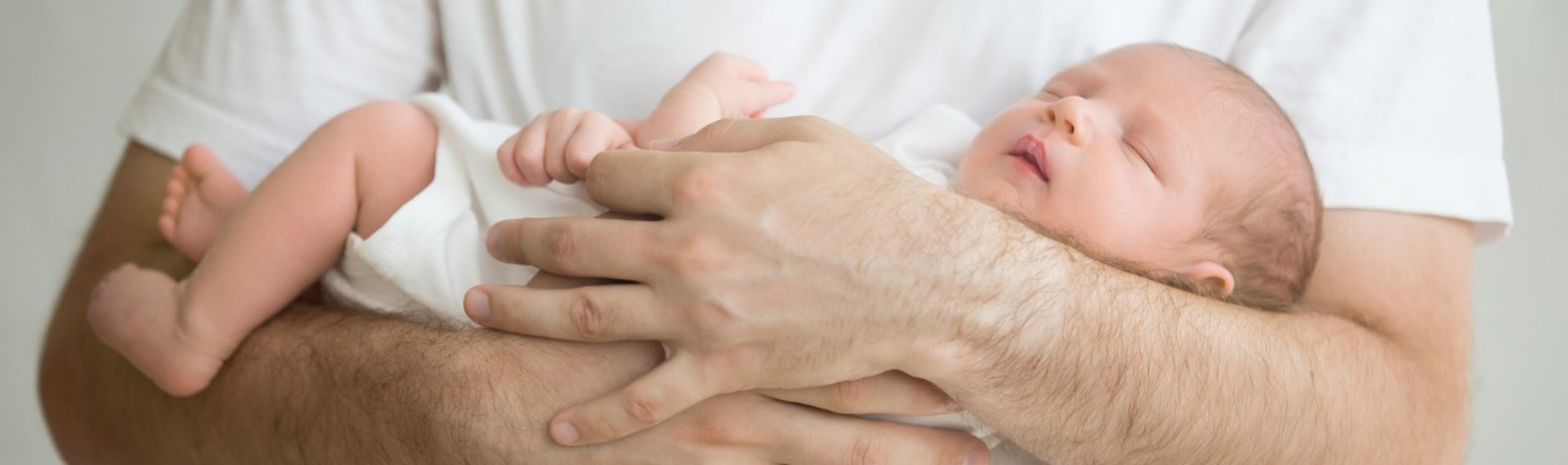 Vaterschaftsurlaub - ein Vater hält sein neugeborenes Kind