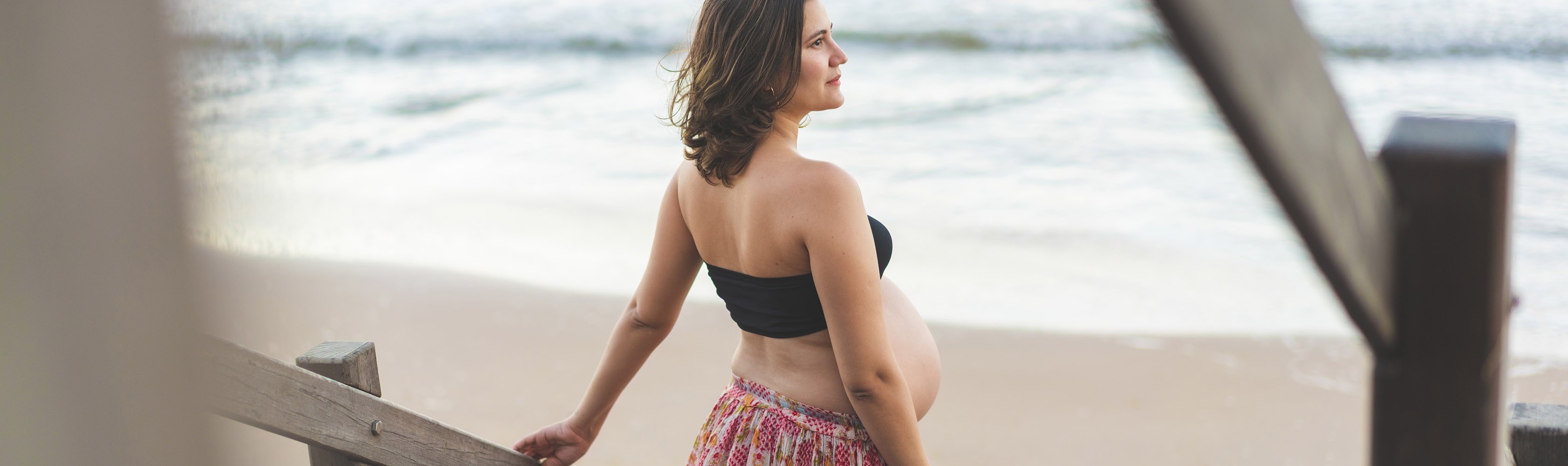 Eine schwangere Frau geniesst einen Strandspaziergang