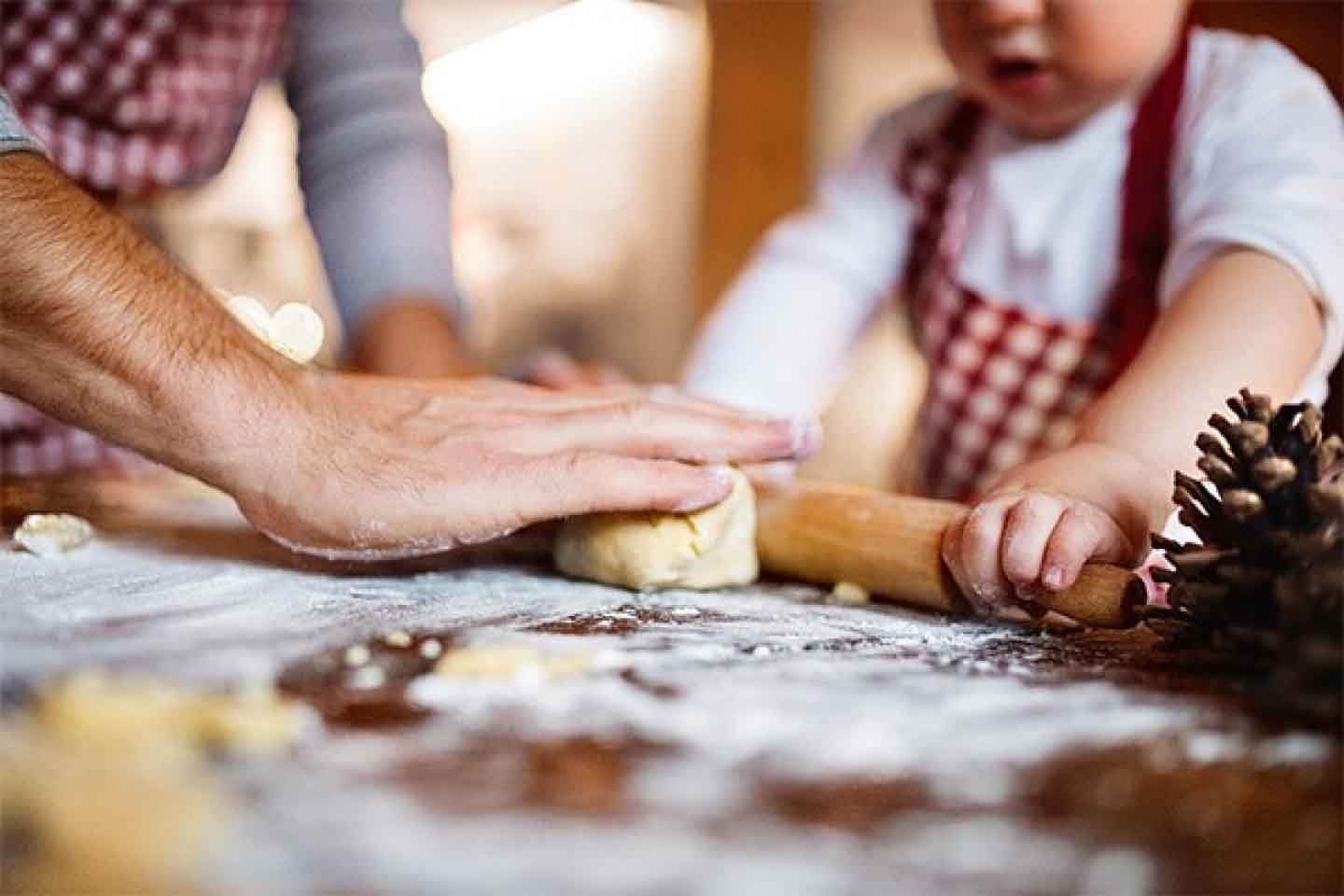 Astuces de cuisine: mettre la main à la pâte en famille, c’est encore plus amusant! Un enfant s’applique à étaler la pâte à biscuits.