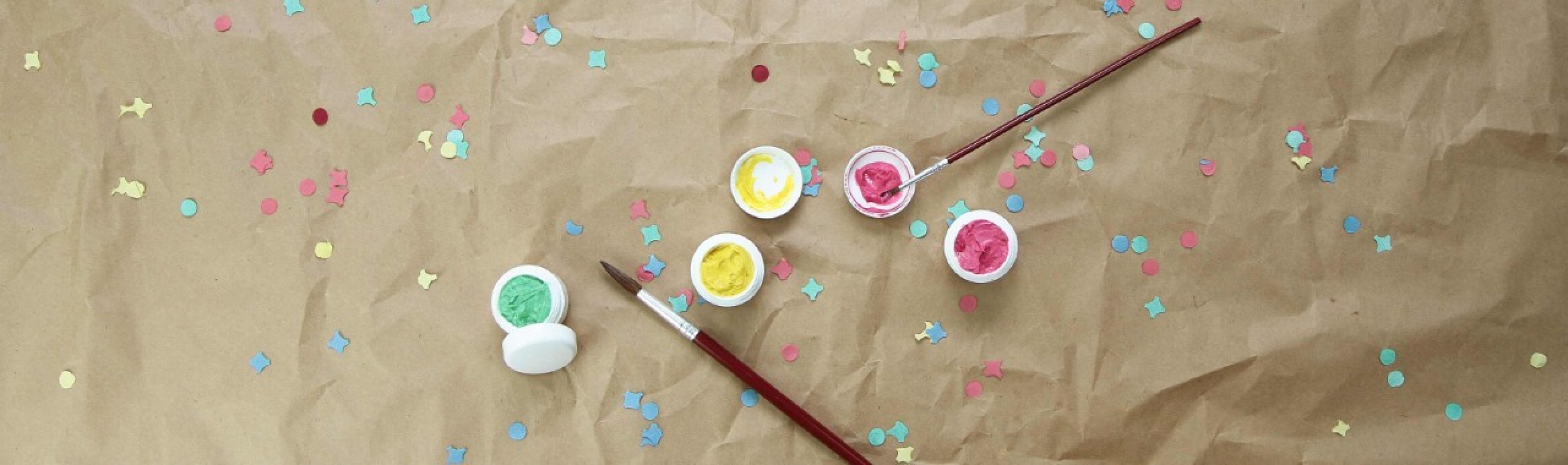 Maquillage et confettis posés sur du papier Kraft