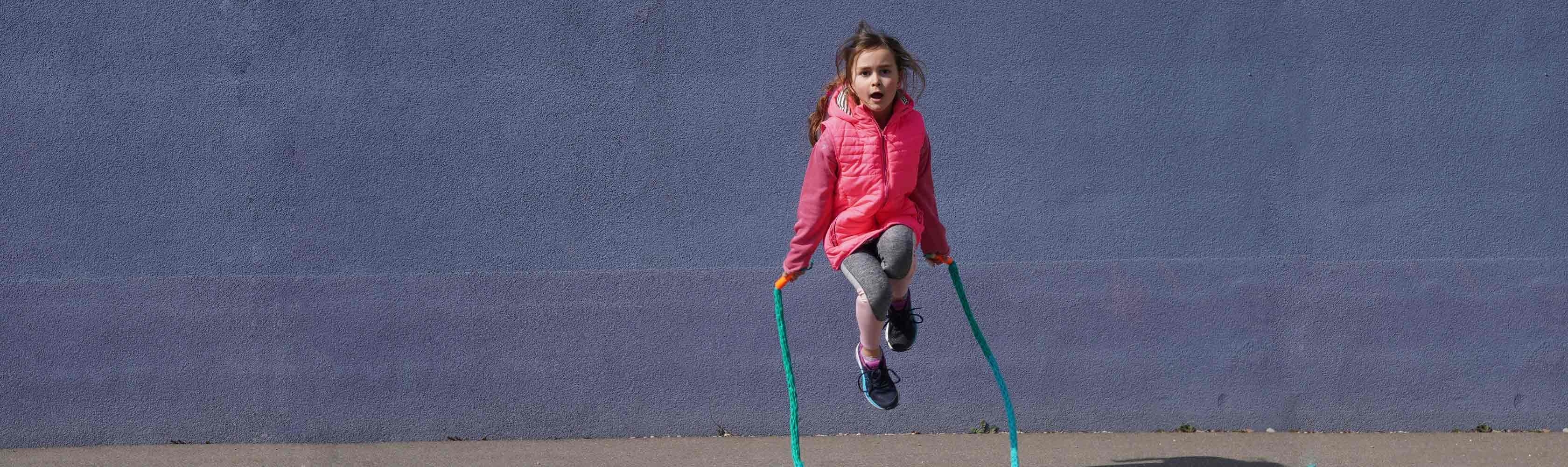 Une petite fille joue à la corde à sauter 