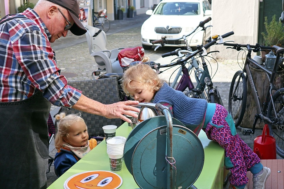 Generationen. Familie. Ruedi Elsener verpflegt sich und seine Enkelkinder mit frischgepresstem Orangensaft.