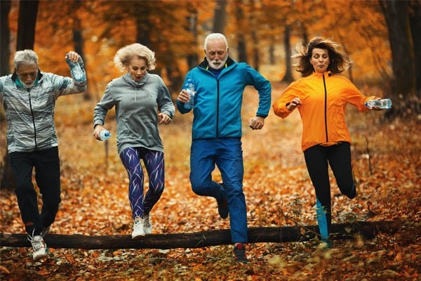 Les bonnes résolutions, telles qu’adopter un mode de vie plus sain, demandent de changer ses habitudes et de surmonter d’éventuels obstacles. Comme ce groupe de joggeurs et joggeuses qui enjambent un tronc d’arbre barrant leur chemin.